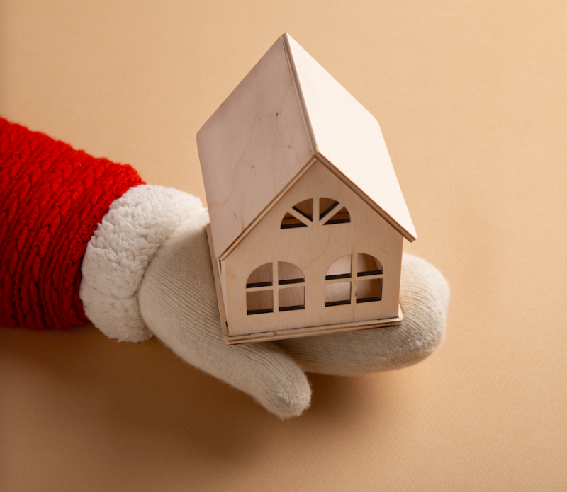 Le père-noël tient une maison dans sa main pour un diagnostic immobilier